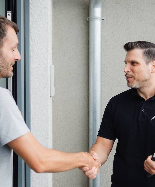 Ein Mann schüttelt einem anderen Mann die Hand.